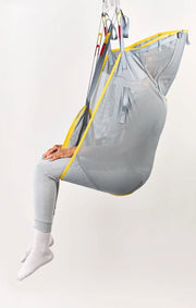 Person sitting in a gray and yellow hammock chair on a white background