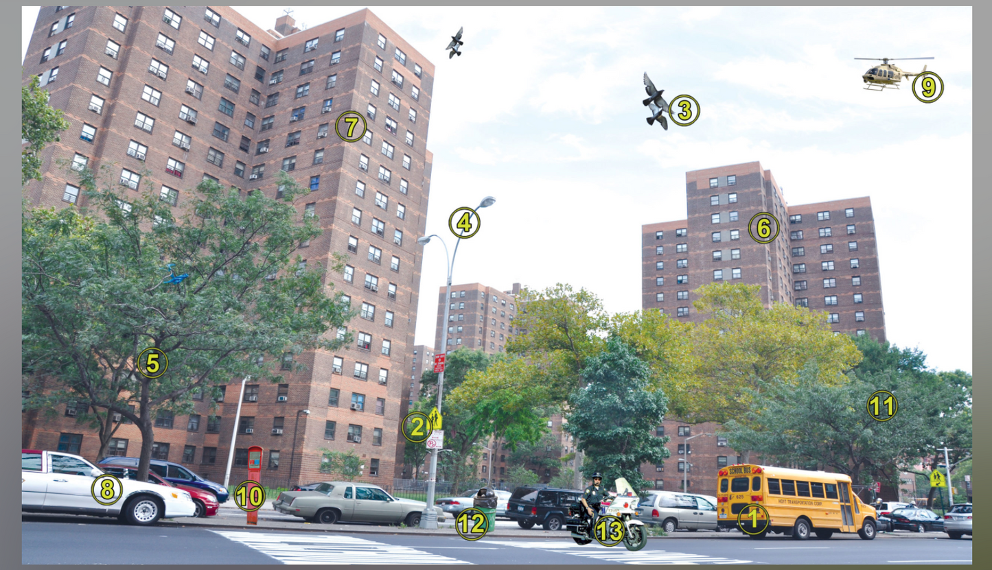 City street scene with buildings, cars, and a school bus.