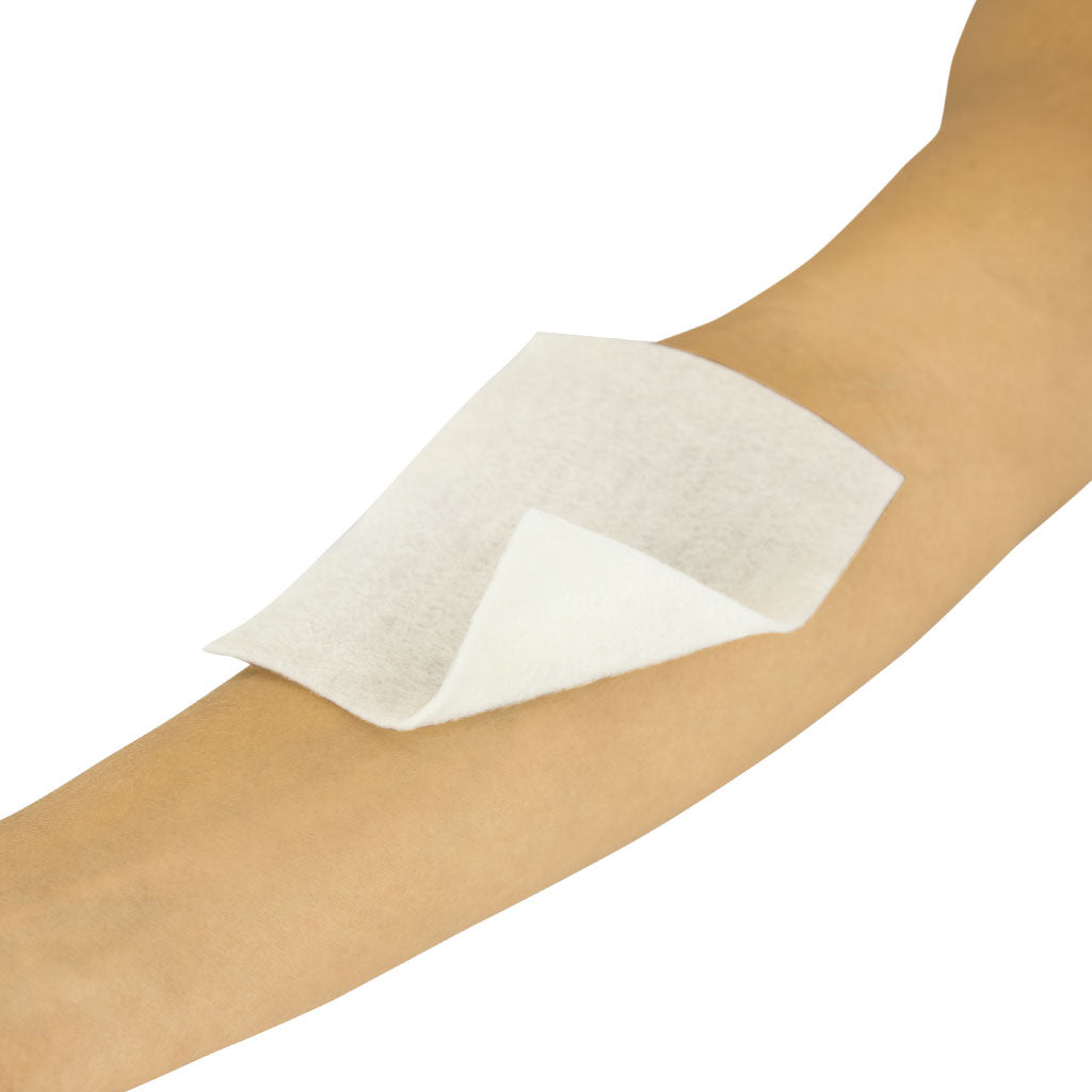 White adhesive patch on a person's arm against a white background