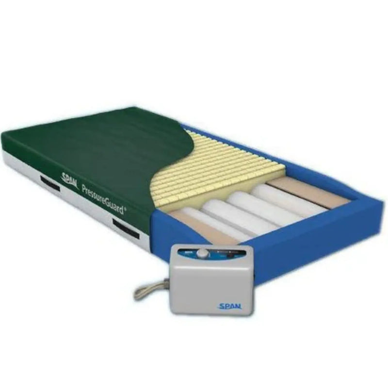 An SPAN PressureGuard bed frame shown open to reveal the mattress layers, including a dark green top, yellow support foam, and white mattress pads, with a small white and blue control box in front on a white background.