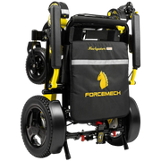 A folded electric wheelchair shown from a rear three-quarter angle on a white background. The wheelchair features a black fabric seat bag with yellow branding for 'FORCEMECH' and 'Navigator', mounted on a black and yellow frame.