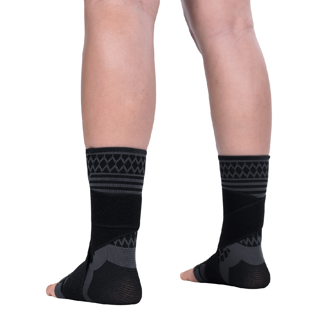 Black compression socks with patterned design worn by a person on a transparent background