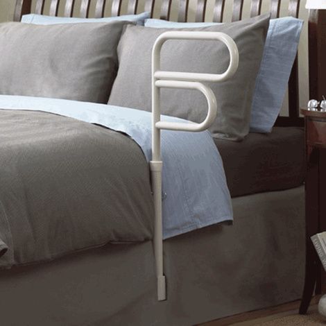 Bed rail in a bedroom setting with bedding and furniture.