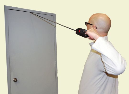 Person using a thermal imaging camera on a plain background