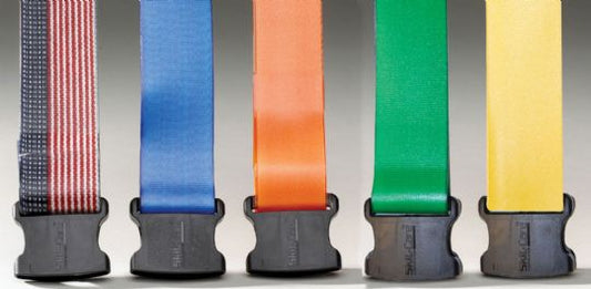 Five colorful belts with black buckles on a gray background