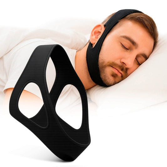 Man sleeping with a black chin strap device on a white pillow