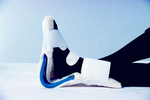 Close-up of a futuristic shoe with white, black, and blue design on a light blue background