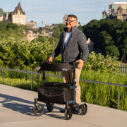 Man pushing a walker outdoors with a scenic background
