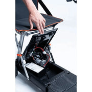 Close-up of a portable workbench with a hand reaching inside, showing its internal components.