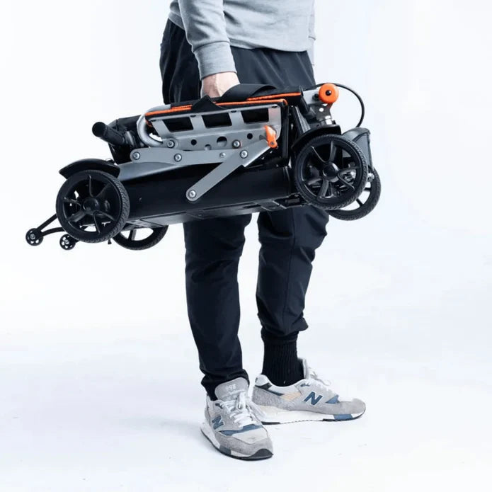 Person holding a folded electric scooter against a white background