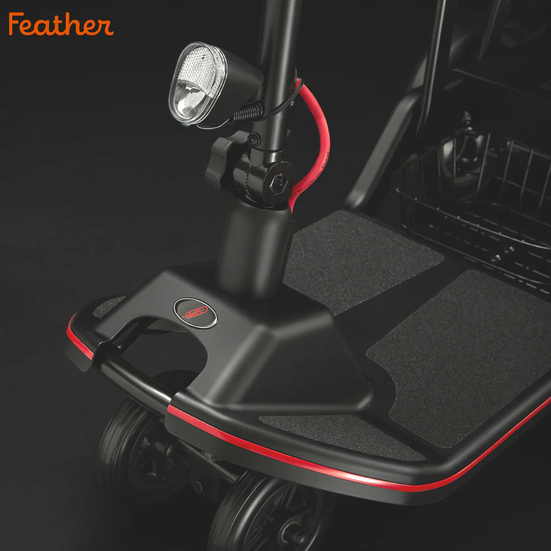 Black and red scooter stand with light on a dark background, featuring the 'Feather' brand.