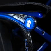 Close-up of a blue and black wheelchair handle with a brand logo.