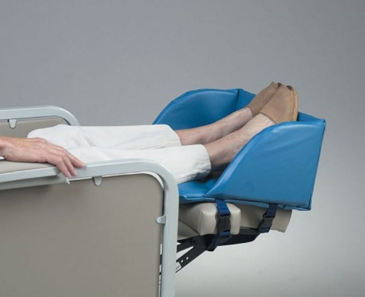 Person using a medical chair with a blue elevated leg rest on a gray background
