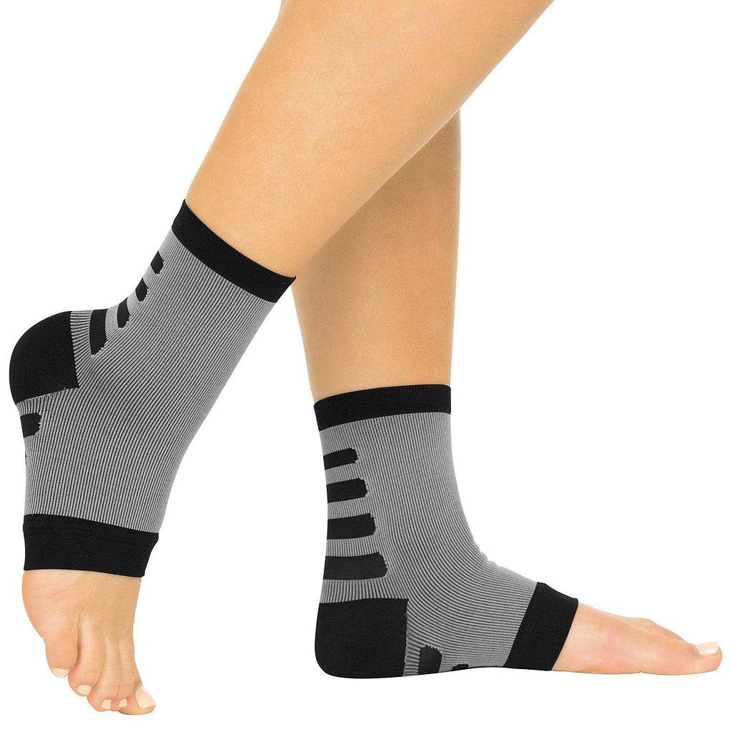 Gray ankle support sleeves with black accents on a person's legs against a white background