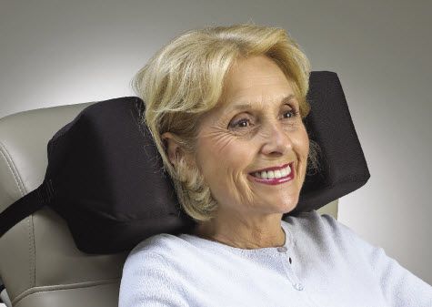 Woman using a black headrest against a neutral background