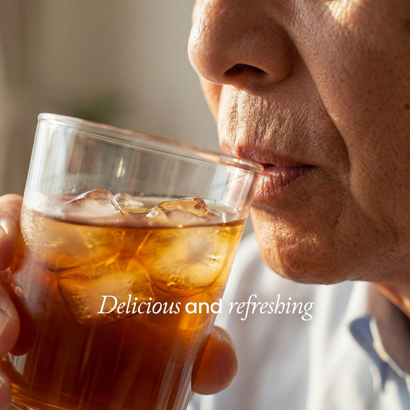 A close-up lifestyle shot of a person drinking an iced cola or iced coffee from a clear glass, with the text 'Delicious and refreshing' overlaid on the bottom.