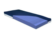 A blue and purple mattress topper or mattress layer shown in a cutaway perspective on a white background.