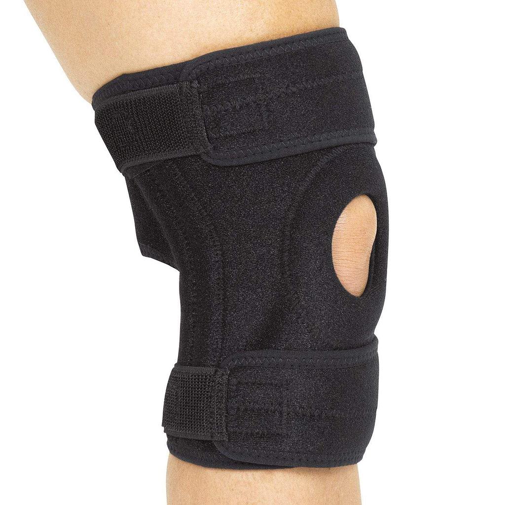 Black knee brace on a person's knee against a white background