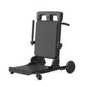 A black adjustable medical or patient transfer chair with a padded backrest, fold-out tray table, side supports, and caster wheels, shown on a plain white background.