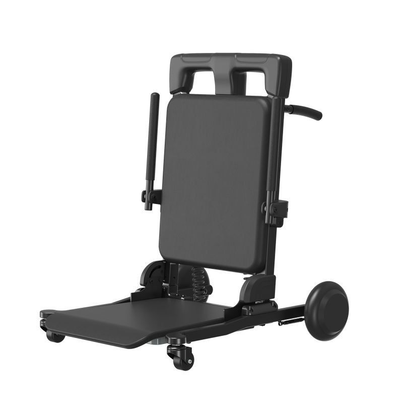A black adjustable medical or patient transfer chair with a padded backrest, fold-out tray table, side supports, and caster wheels, shown on a plain white background.