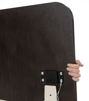 Hand holding a black rectangular object with a metal bracket