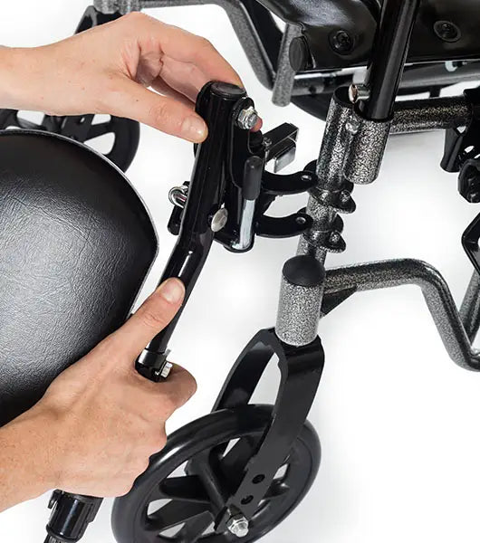 Close-up of a person adjusting a wheelchair's footrest on a white background