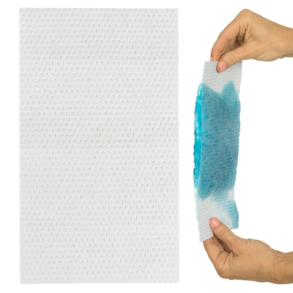 Hand holding a piece of textured white paper with blue water stain on a white background