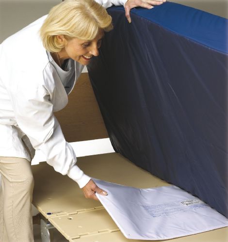 woman putting bed pad under a mattress