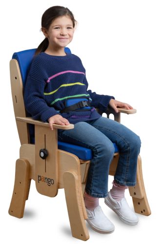 Child sitting on a wooden chair with blue cushion, wearing a navy sweater with colorful stripes.