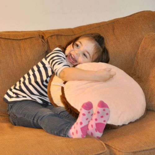 Child hugging a large plush toy on a brown couch