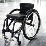 Black wheelchair with large wheels on a reflective floor