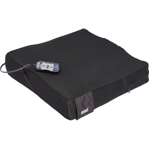 Black cushion with a remote control on a white background