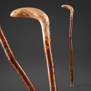 Two wooden walking canes on a dark gray background