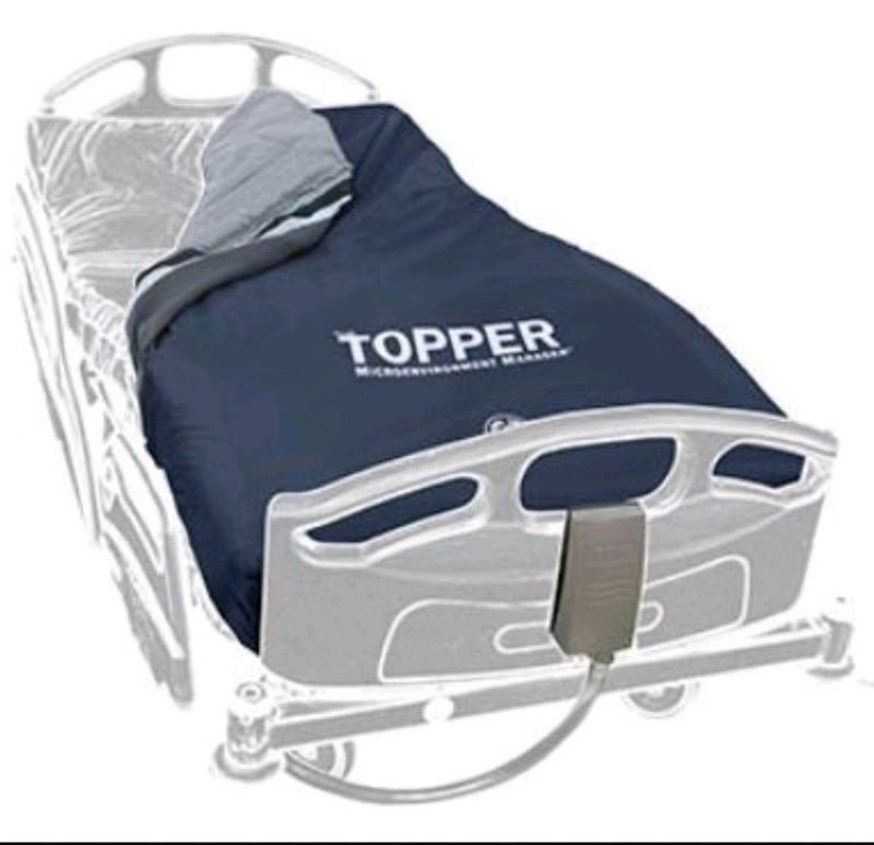 A navy blue TOPPER Microenvironment Manager blanket draped over a hospital bed frame, shown against a plain white background.