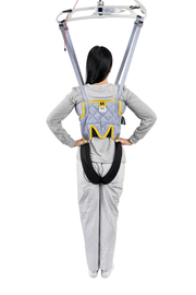 A person viewed from behind wearing a gray and yellow back support harness with a black waist belt, suspended from a white overhead frame against a white background.