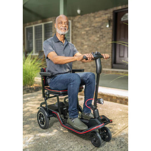 Man using a mobility scooter outdoors on a patio.