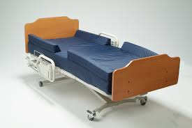 Medical bed with wooden frame and blue mattress on a white background