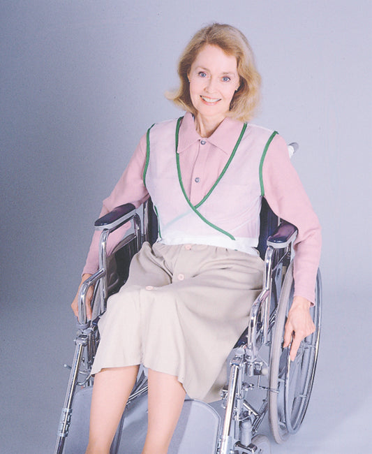 Woman in a wheelchair wearing a pink blouse with green trim against a gray background