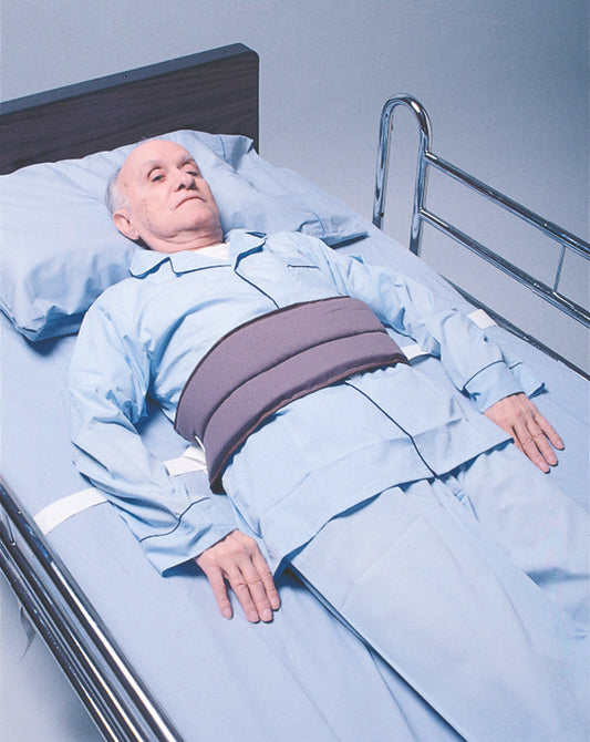 Man lying in bed with a medical belt around his waist