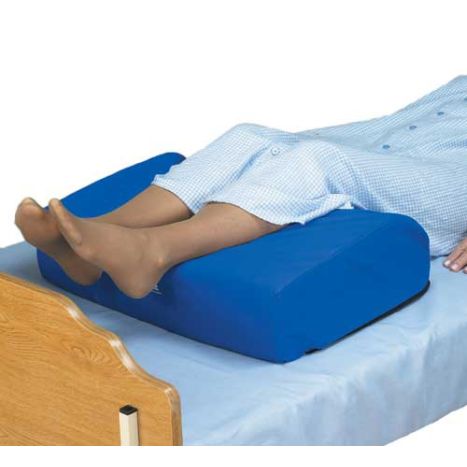 Person using a blue footrest on a bed with a white background
