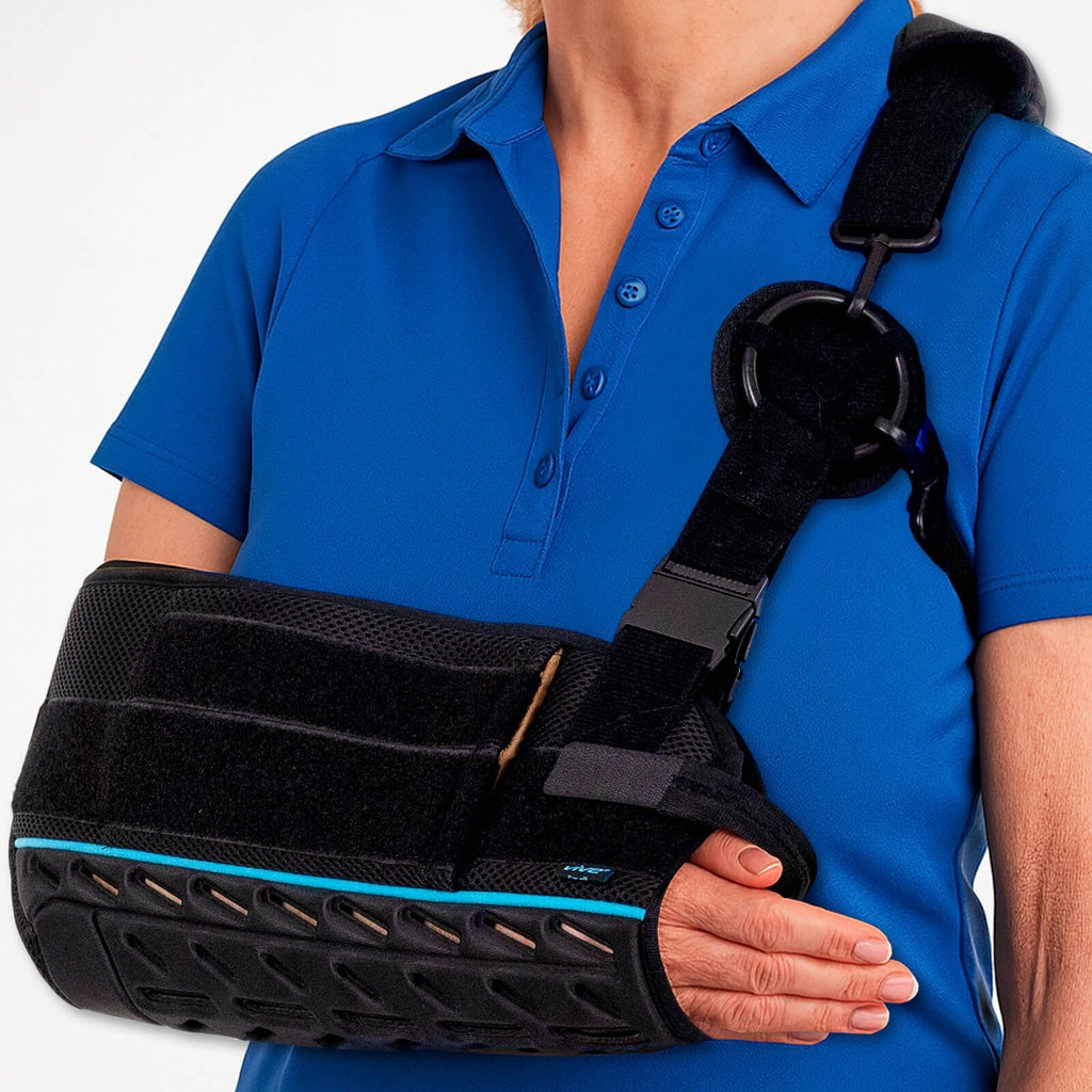 Person wearing a blue shirt with a black shoulder brace on a white background