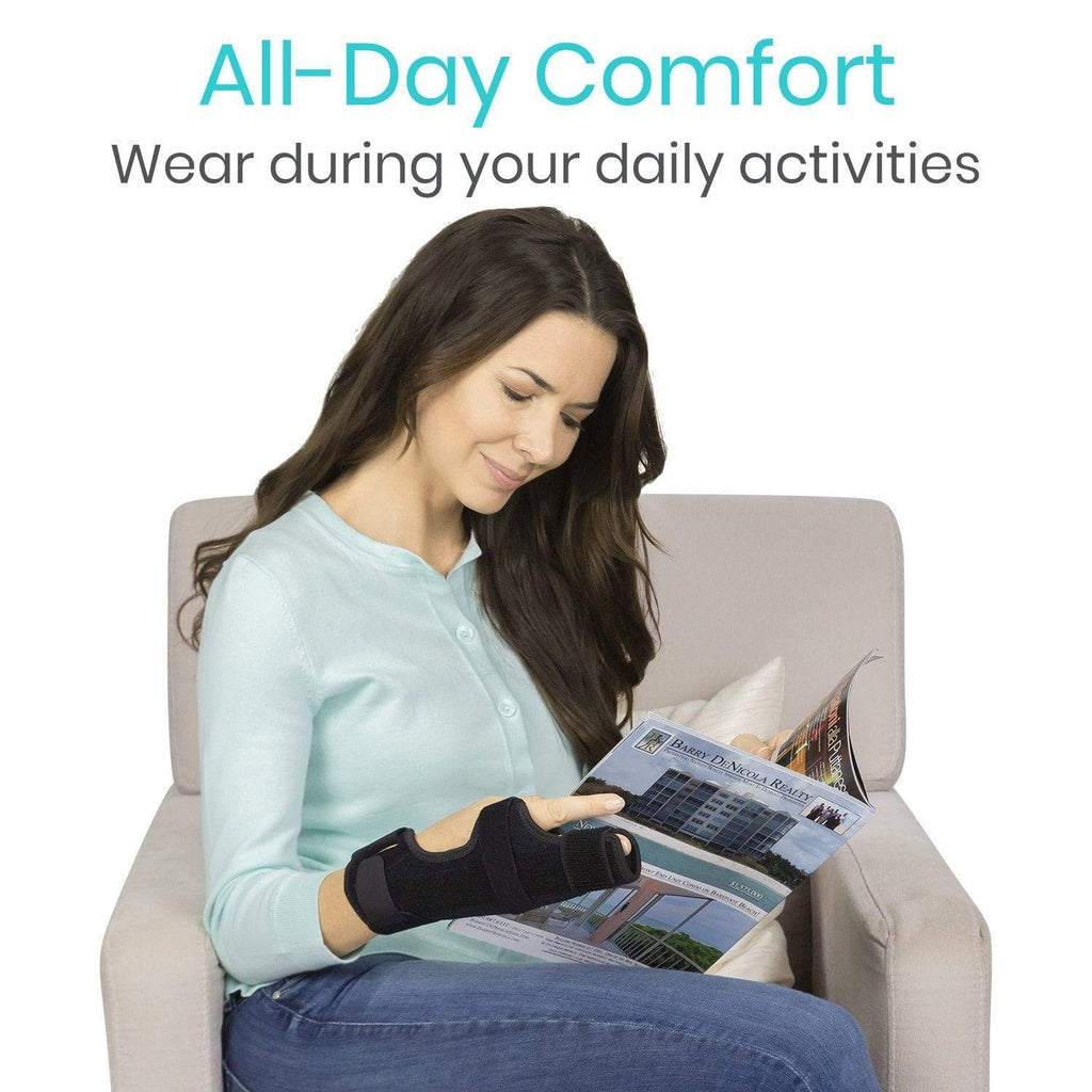Woman reading a magazine wearing a black wrist brace with 'All-Day Comfort' text above.