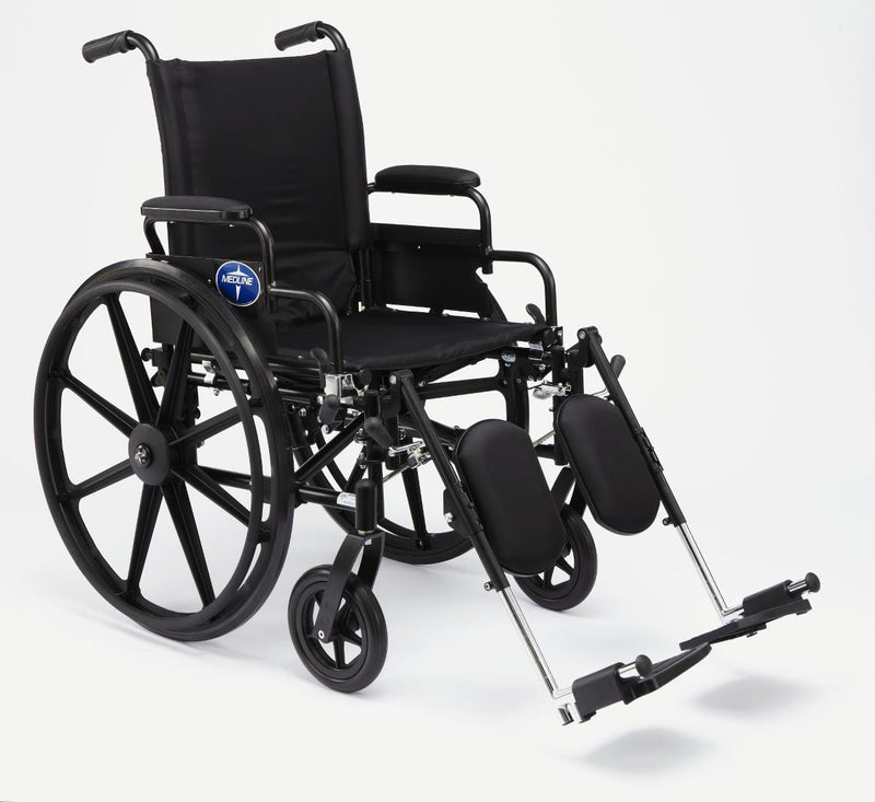 A black manual wheelchair with a high backrest, black fabric seat and armrests, large spoked rear wheels, small front casters, and fold-out footrests, photographed on a clean light gray studio background.