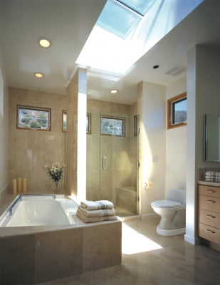 Modern bathroom with a skylight, bathtub, and toilet.