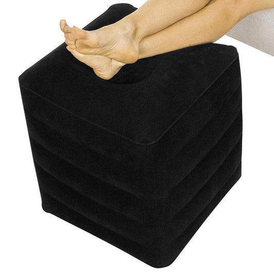 Black footstool with a person's foot on top, on a white background