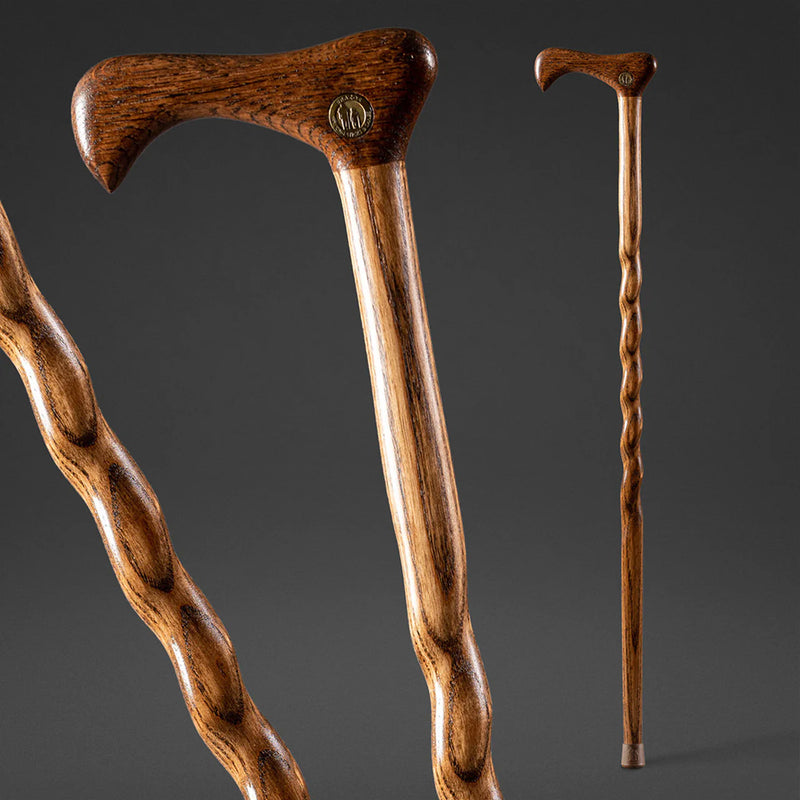 Two wooden walking sticks with intricate designs on a dark background