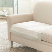 Beige sofa with a transparent pet barrier on a wooden floor in a living room.