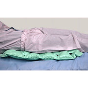 Bed with pink checkered sheets and a green pillow on a plain background