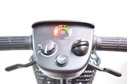 Close-up of a motorcycle handlebar with control panel and indicator lights on a white background
