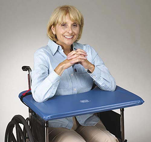 Woman in a wheelchair with a blue tray attached, smiling against a plain background